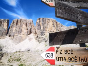 cartello del sentiero 638 direzione Piz Boè con le montagne del Gruppo del Sella come sfondo