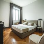 stanza con letto e poltrona Guest House Milano
