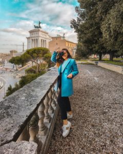 Ragazza con un cappotto azzurro presso Piazzale Caffarelli di Roma con il Vittoriano sullo Fondo, Roma. E' uno dei posti Instagrammabili di Roma