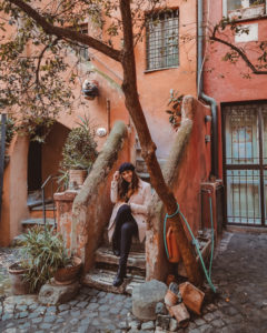 Ragazza vestita di rosa presso l'Arco degli Acetari a Campo dei Fiori, Roma